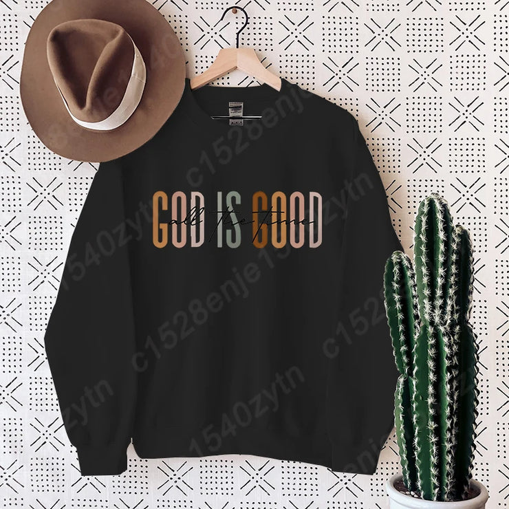 Black sweatshirt with God is Good text hanging on wall with brown hat and cactus Christian clothing women