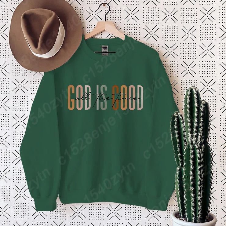 Green crewneck sweatshirt with God is Good print styled as Christian clothing women with brown hat and cactus