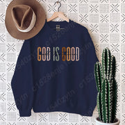 Navy blue Christian clothing women sweatshirt with God is Good text hanging next to brown hat and cactus
