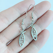 Silver Christian fish earrings with Jesus inscription held in hand from Fresh Faith Designs