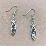 Fresh Faith Designs silver Christian fish earrings with Jesus cutout on beige background