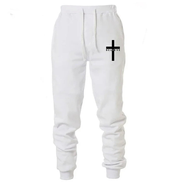 White Christian jogging pants with black cross and believe text on left thigh by Fresh Faith Designs