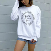 White Christian women's sweatshirt with faith over fear wreath design worn with denim shorts