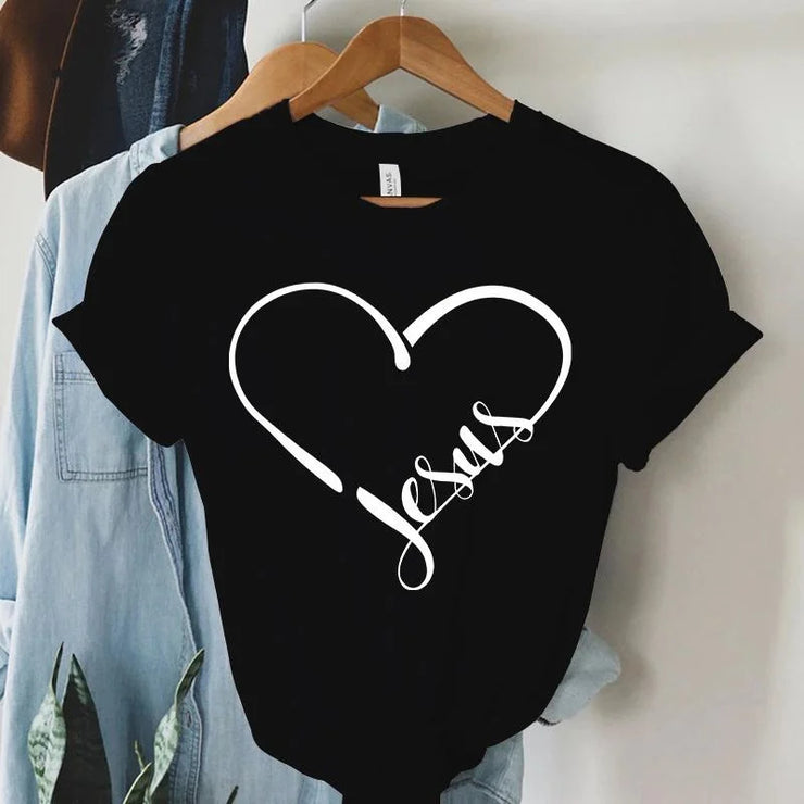 Black Christian women's t-shirt with white heart and Jesus script design hanging on wooden hanger