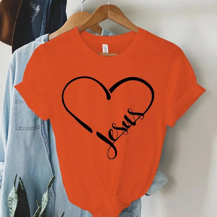 Orange Christian women's t-shirt with heart outline and Jesus script design hanging on wooden hanger