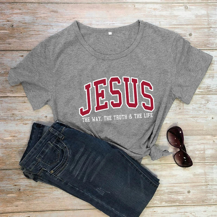 Christian women's vintage t-shirt in gray with Jesus slogan styled with dark jeans and sunglasses