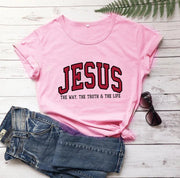 Pink Christian women's vintage t-shirt with JESUS text and slogan styled with jeans and sunglasses