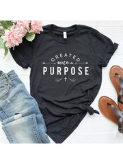 Black Created with a Purpose shirt featuring white typography and cross design styled with jeans and sandals