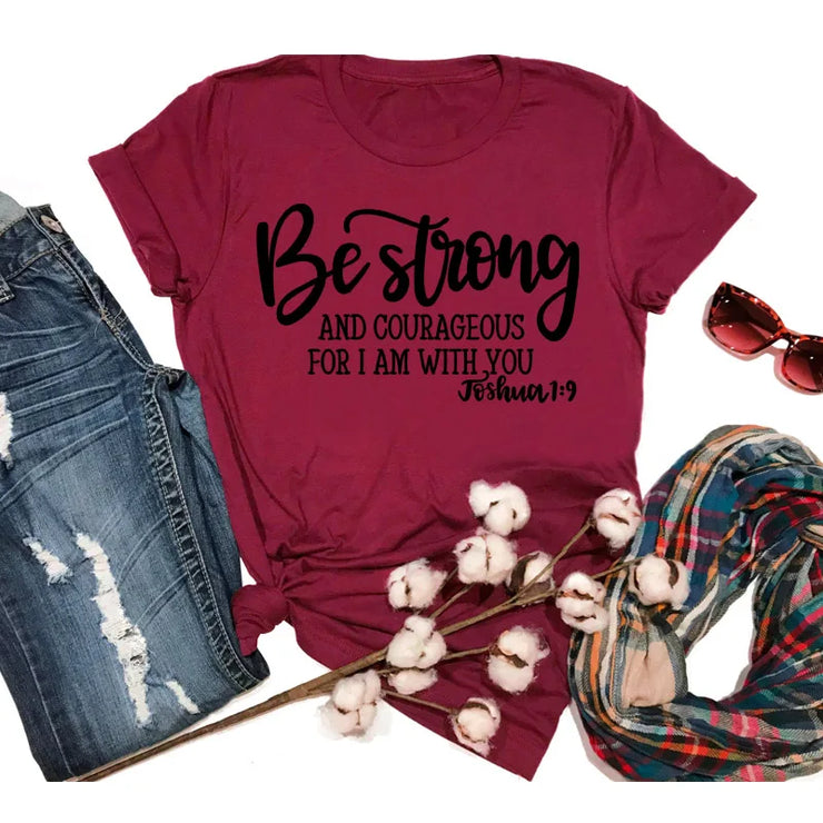 Maroon t-shirt with Be strong and courageous Joshua 1:9 text Faith Based Apparel paired with distressed jeans and plaid scarf