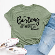 Olive green faith based apparel t-shirt with Be strong and courageous Joshua 1 9 text paired with light blue jeans and white Converse shoes