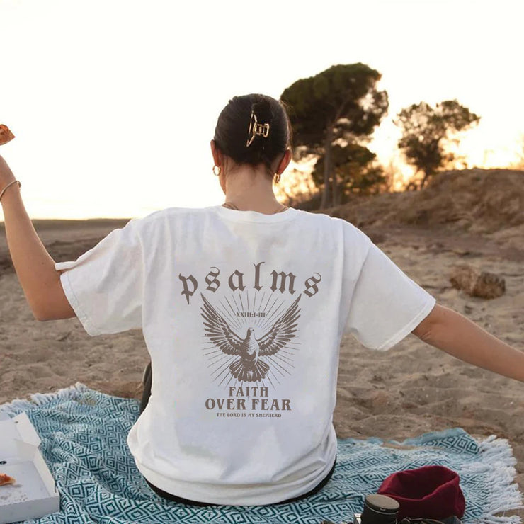 Woman wearing white Psalms faith based apparel t-shirt with eagle design sitting on beach towel