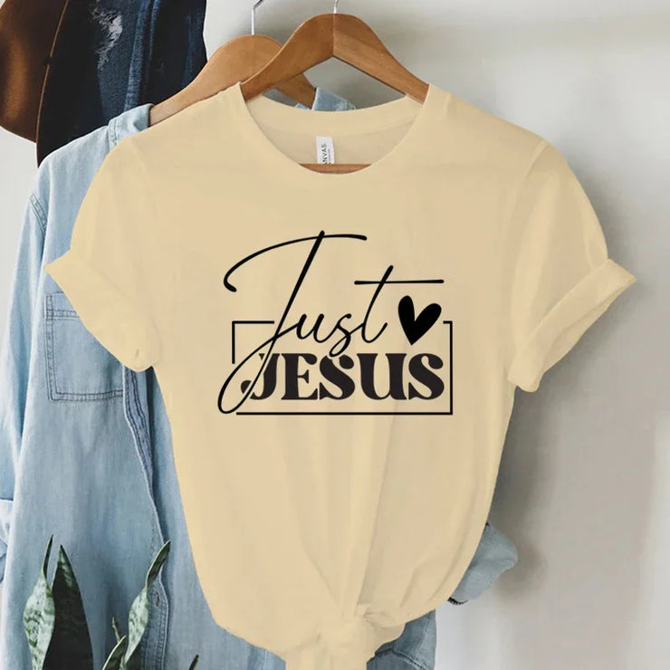 Cream t-shirt with Just Jesus design in black hanging on wooden hanger faith-based women's apparel