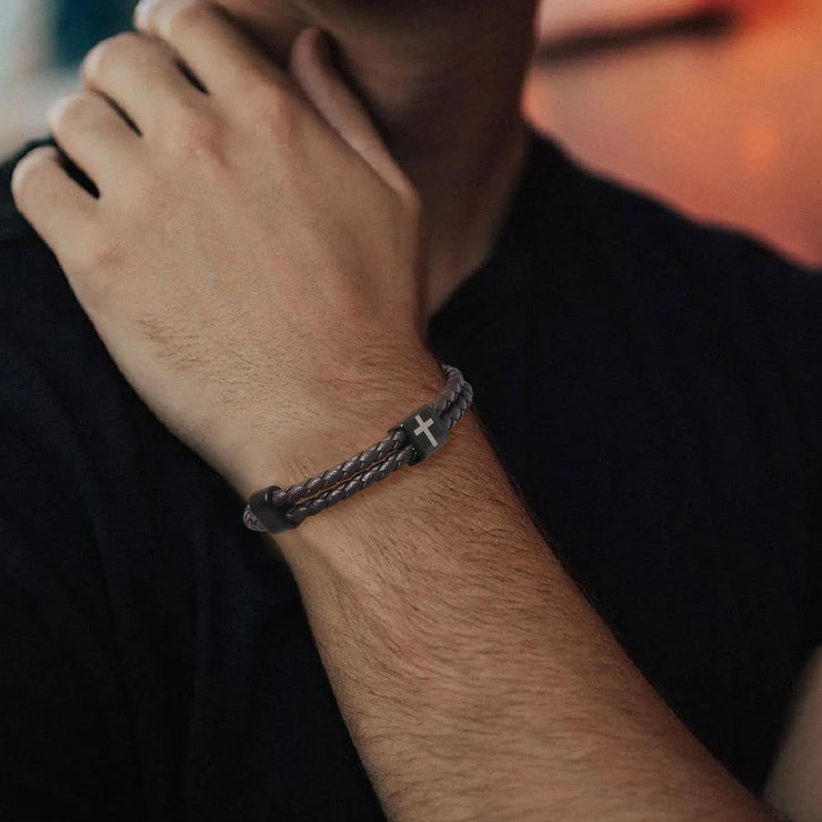 Braided leather bracelet with black cross charm worn on wrist faith jewelry for men