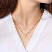 Gold cross necklace on woman wearing white blouse faith jewelry for women by Fresh Faith Designs