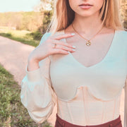 Fresh Faith Designs gold necklace worn by woman featuring faith jewelry for women with a delicate pendant