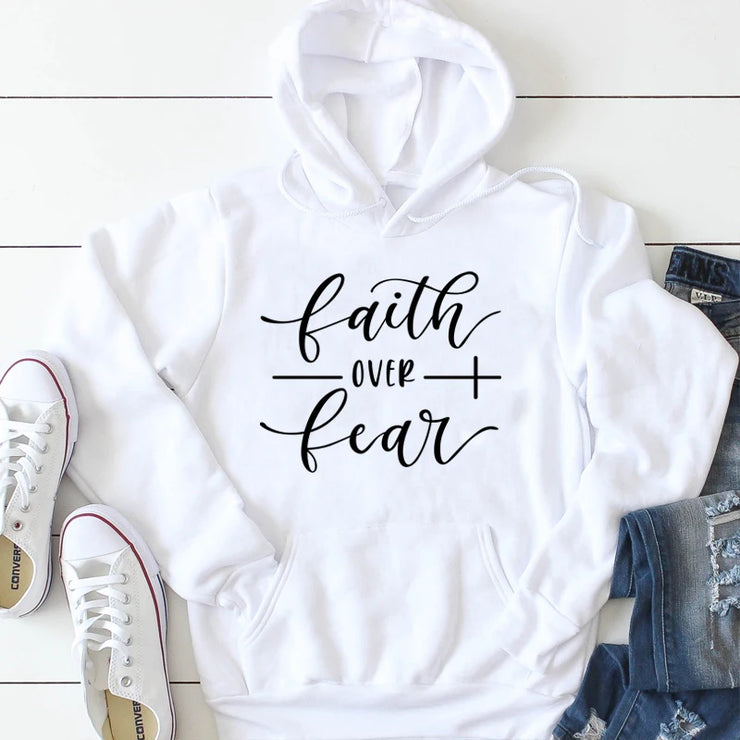 White hoodie with faith over fear print paired with casual jeans and white sneakers religious casual apparel