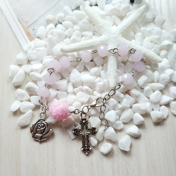 Fresh Faith Designs religious jewelry for women featuring a pink beaded bracelet with cross and rose charms