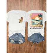 Fresh Faith Designs Bible verse beach shirt with floral front and sunset ocean back print paired with denim shorts
