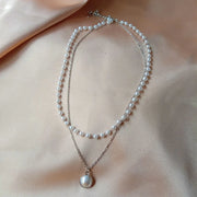Fresh Faith Designs fashion crystal cross necklace featuring layered pearl and silver chains on satin background