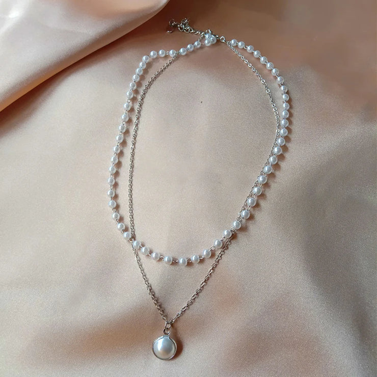 Fresh Faith Designs fashion crystal cross necklace featuring layered pearl and silver chains on satin background
