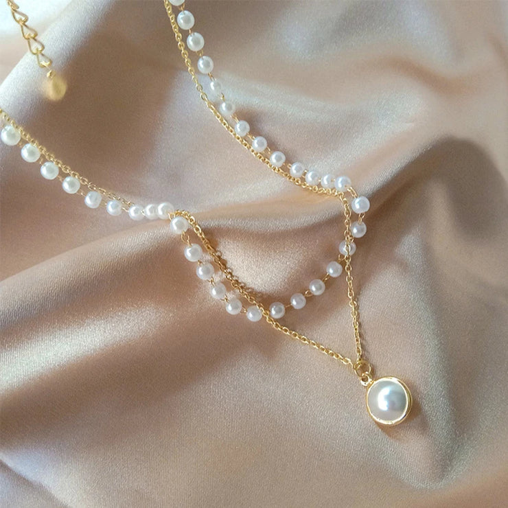 Fresh Faith Designs fashion crystal cross necklace with gold chain and pearl accents on satin background