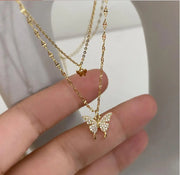Fresh Faith Designs fashion crystal cross necklace with gold butterfly pendant held in hand