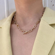 Fresh Faith Designs fashion crystal cross necklace with chunky gold chain worn with a light yellow blazer