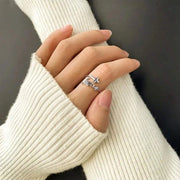 Silver women's Christian rings with cross and faith design worn on hand with white knit sleeves