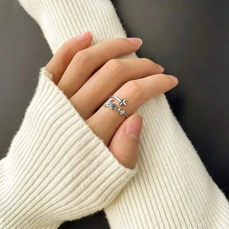 Silver women's Christian rings with cross and faith design worn on hand with white knit sleeves